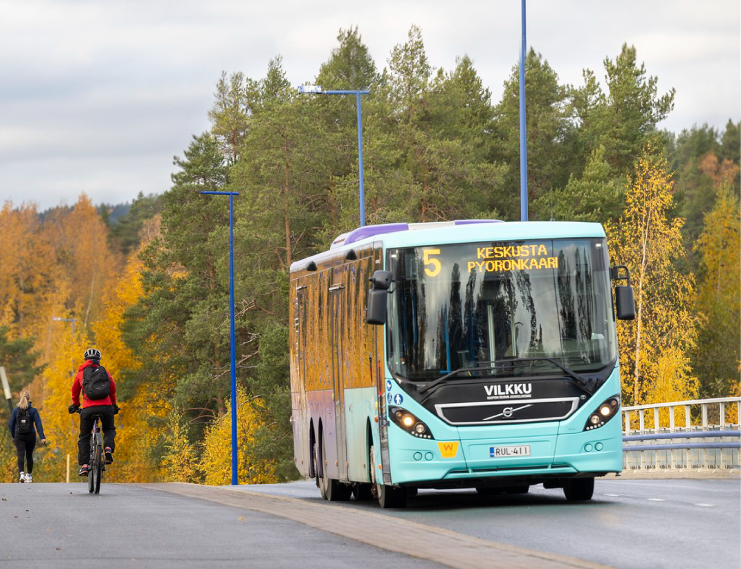 Kuvassa bussi syksyisessä maisemassa
